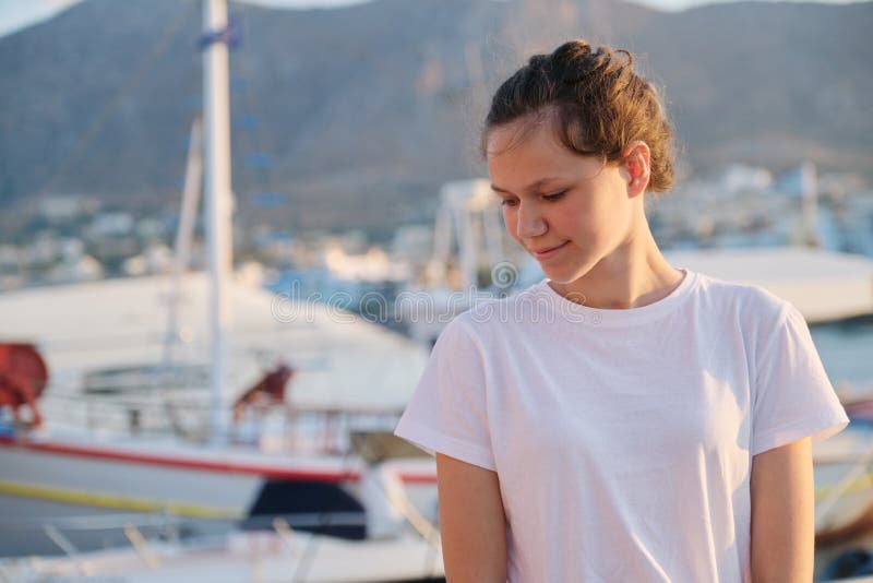 Portrait of teenage girl 15 years old, happy smiling teenager. Summer sunset sea harbor with yachts background. Vacation, adolescence, travel concept stock image