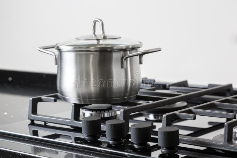 Pot on a gas stove. New iron pot on a black gas stove on a kitchen stock photography