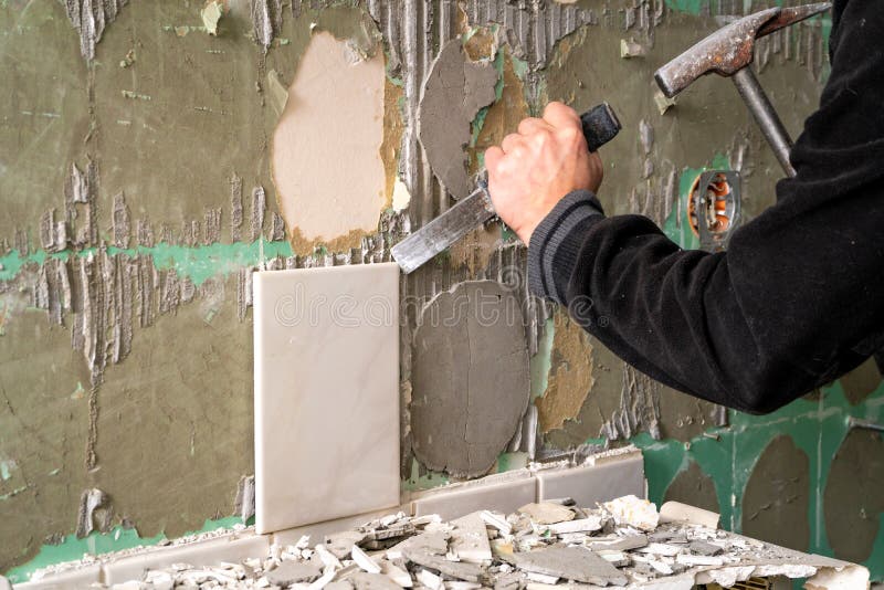 Preparation of repair the bathroom. Man Removing old tiles.  stock photos