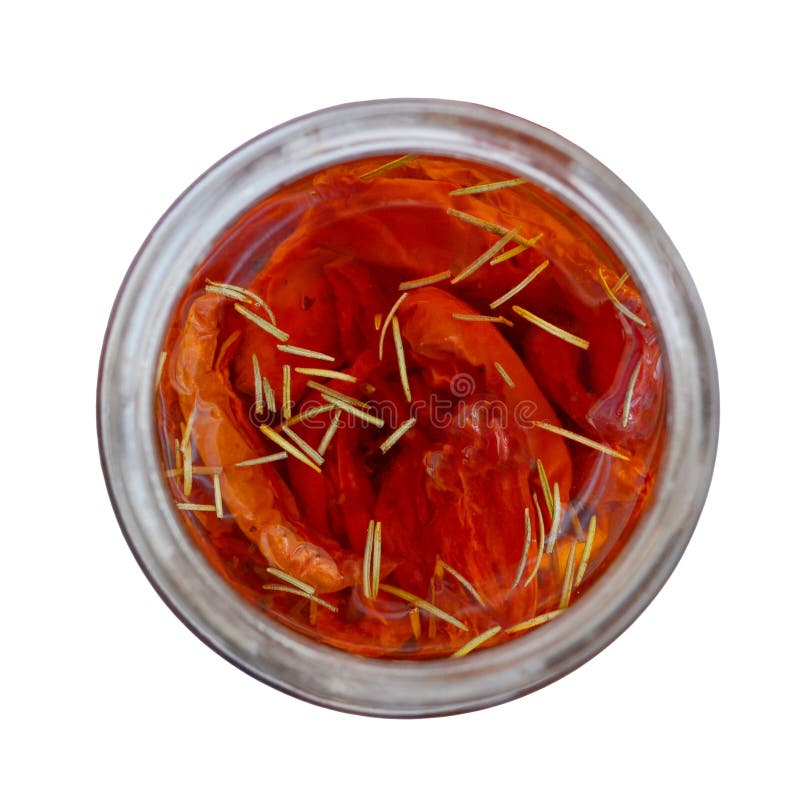 Red homemade oven dried tomatoes with rosemary stuffed with olive oil in a glass jar, top view, close-up, isolated stock photography