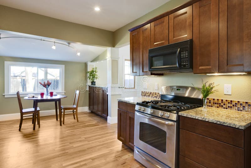 Remodel kitchen with wood flooring. Remodel kitchen with oven, granite counters, and reflective wood floor royalty free stock photography