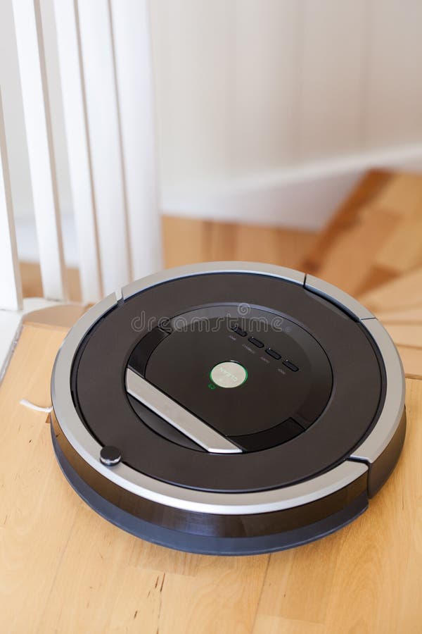 Robotic vacuum cleaner on laminate wood floor smart cleaning technology stairs.  stock photos