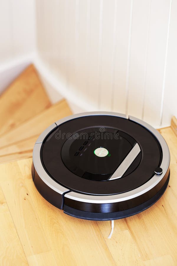 Robotic vacuum cleaner on laminate wood floor smart cleaning technology stairs.  royalty free stock images