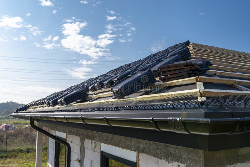 Roof ceramic tile arranged in packets on the roof on roof battens. Preparation for laying roof tiles. Roof ceramic tile arranged in packets on the roof on roof royalty free stock photo