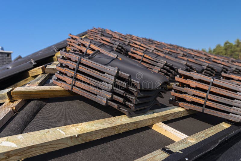 Roof ceramic tile arranged in packets on the roof on roof battens. Preparation for laying roof tiles. Roof ceramic tile arranged in packets on the roof on roof royalty free stock image