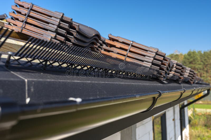 Roof ceramic tile arranged in packets on the roof on roof battens. Preparation for laying roof tiles. Roof ceramic tile arranged in packets on the roof on roof royalty free stock images