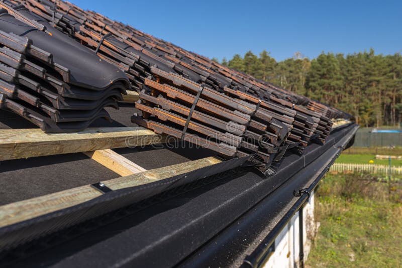 Roof ceramic tile arranged in packets on the roof on roof battens. Preparation for laying roof tiles. Roof ceramic tile arranged in packets on the roof on roof royalty free stock image