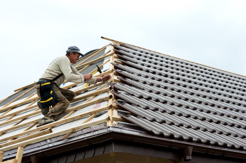 Roofer laying tiles royalty free stock photo