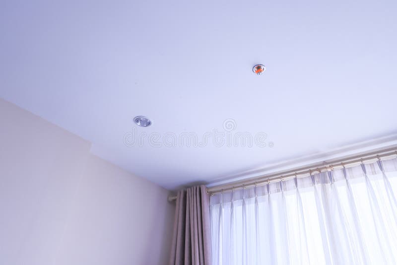 Room in house, with white curtains, fire sprinklers and LED light bulbs on white ceilings. Room in house, with transparent white curtains, fire sprinklers and royalty free stock photography