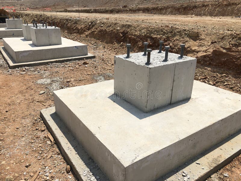 Row of reinforced concrete foundations with metal anchor bolts for the installation of metal columns. Row of reinforced concrete foundations with metal anchor stock image