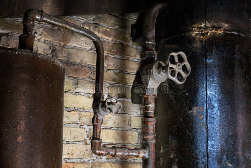 Rusty boiler room pipes. Old metal boiler generating heating and delivering it to home through pipeline. Hot water or gas is being. Delivered with this system stock images