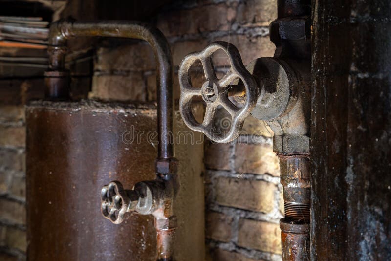 Rusty boiler room pipes. Old metal boiler generating heating and delivering it to home through pipeline. Hot water or gas is being. Delivered with this system royalty free stock image