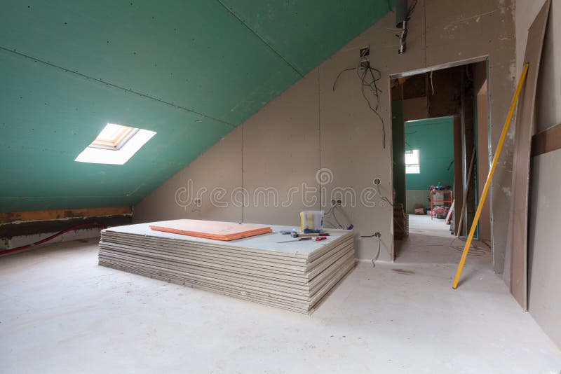 Sheets of drywall, parts of scaffolding, handle tools and construction material in the room of apartment during on the remodeling stock photos