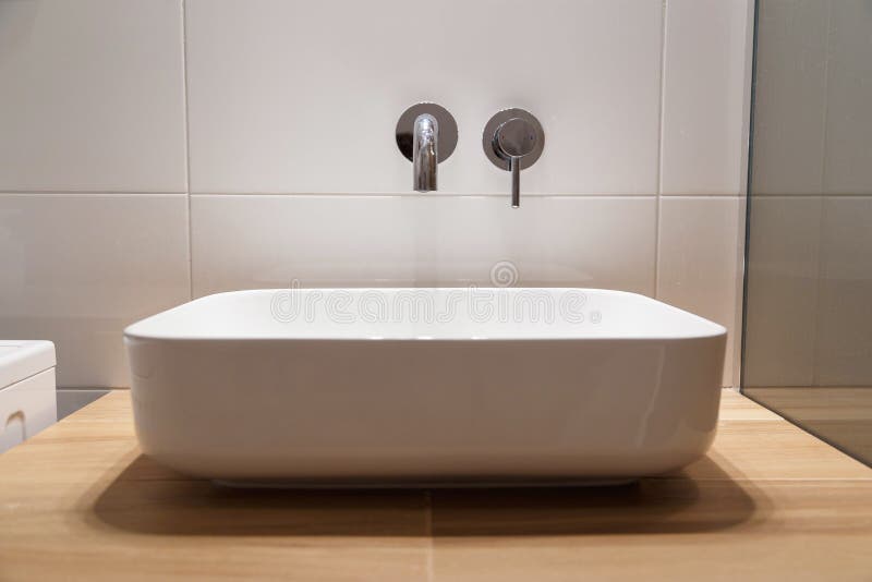 Sink and wall-mounted washbasin mixer stock photo