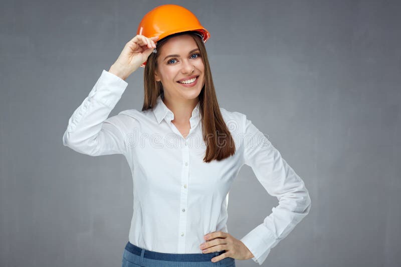 Smiling woman engineer builder worker touching her protect helmet. stock image