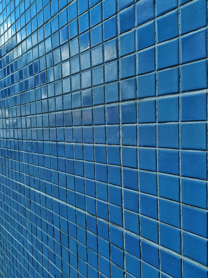 Square pattern blue tiled wall. Blue pool tiles. Dark blue small tiles on a wall. Facade of bathroom. Parede de azulejos azuis. Square pattern blue tiled wall stock images