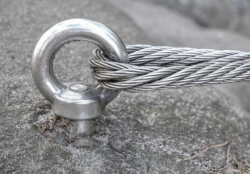 Stainless cable fixed to the rock for the safety. Mountain iron anchor for free climbing. Stainless cable fixed to the rock for the safety of the walking route royalty free stock photography