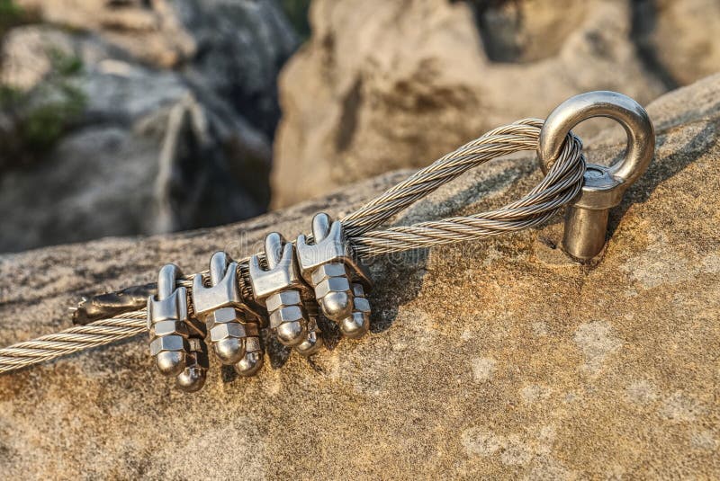 Stainless cable fixed to the rock for the safety. Mountain iron anchor for free climbing. Stainless cable fixed to the rock for the safety of the walking route stock photo