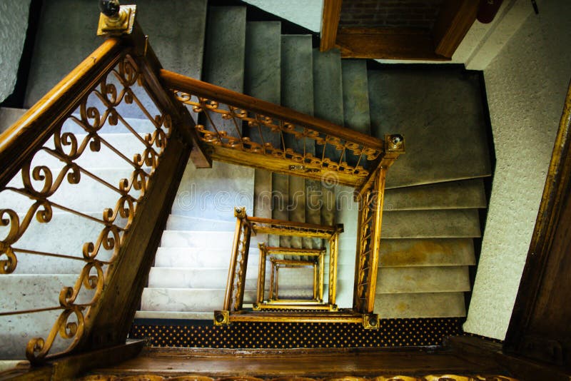 Staircase stairway. Old vintage squared spiral multi-flight stairs stairway with brown wood and metal handrails. Old vintage squared spiral multi-flight stairs stock image