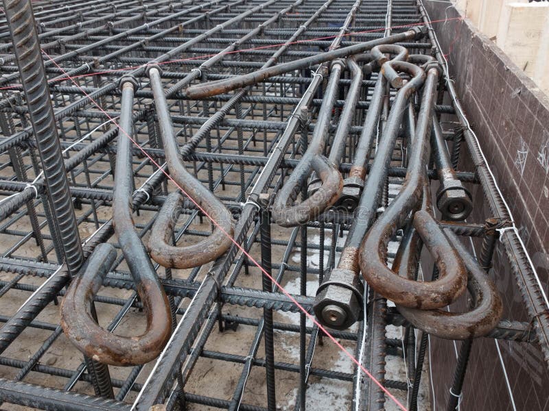 Steel anchor bolts. With nuts laying on the steel grid of tower crane footing reinforcement royalty free stock images