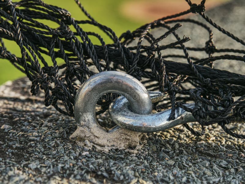 Steel twisted rope and bolt anchor eye in concrete. Steel twisted rope and steel bolt anchor eye in concrete base. The end knot of steel rope royalty free stock photography