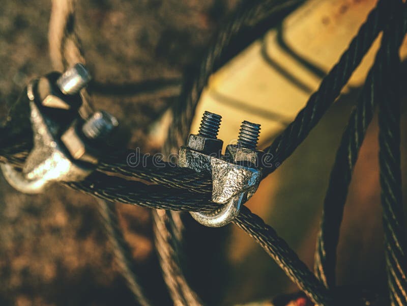 Steel twisted rope and bolt anchor eye in concrete. Steel twisted rope and steel bolt anchor eye in concrete base. The end knot of steel rope work wire weld wall stock photos