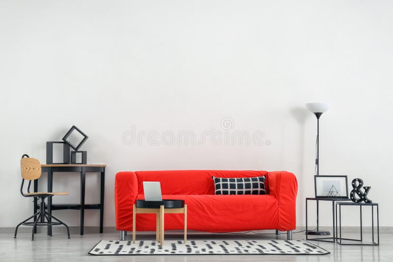 Stylish furniture with comfortable sofa near light wall royalty free stock image