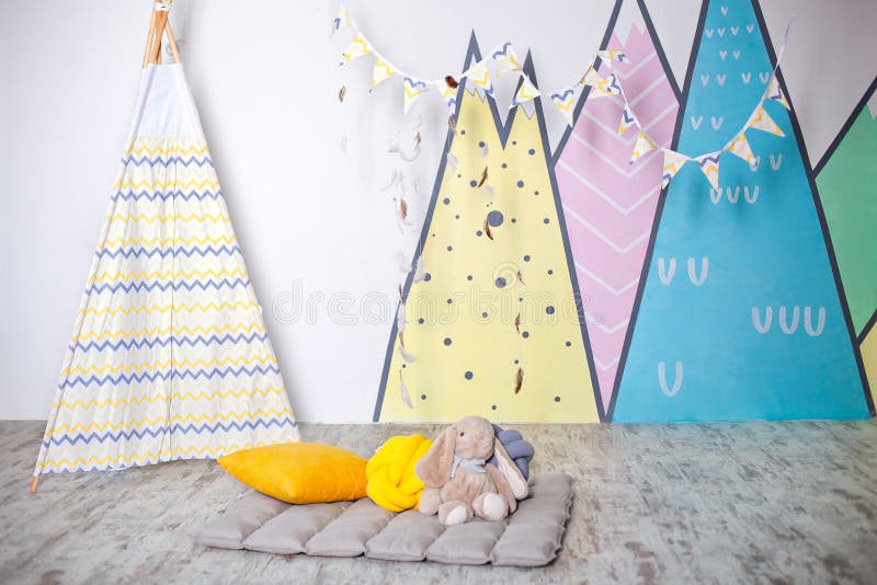 Stylish white modern kids room. Kids wigwam in childrens room. Scandinavian style of interior. Spacious bedroom for a child with a royalty free stock photo