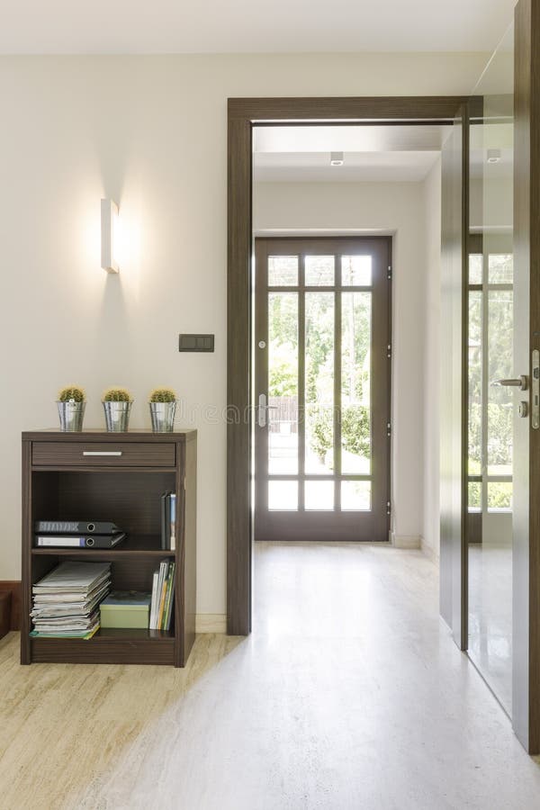 Sunny anteroom with transparent door. Very bright corridor of a freshly-built house, with travertine floor and transparent entrance door stock photos