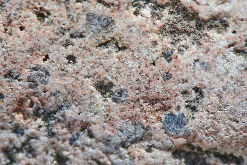 The surface of the chipped granite stone, rough, unpolished with multicolored splashes, natural, not treated, as a background for. The surface of the chipped stock photos