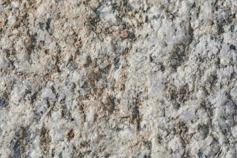 The surface of the chipped granite stone, rough, unpolished with multicolored splashes, natural, not treated, as a background for. The surface of the chipped stock images