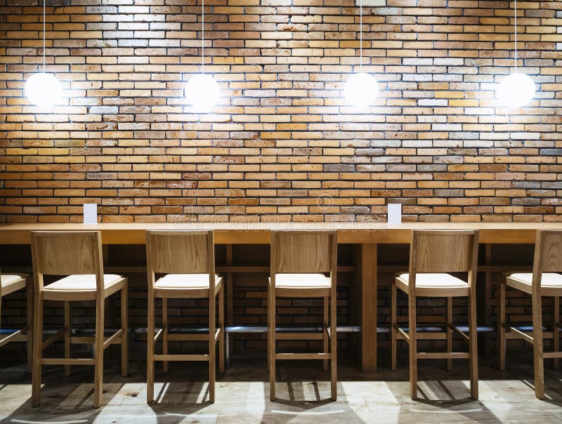 Table counter Bar with Chairs and Lights Brick wall background stock image