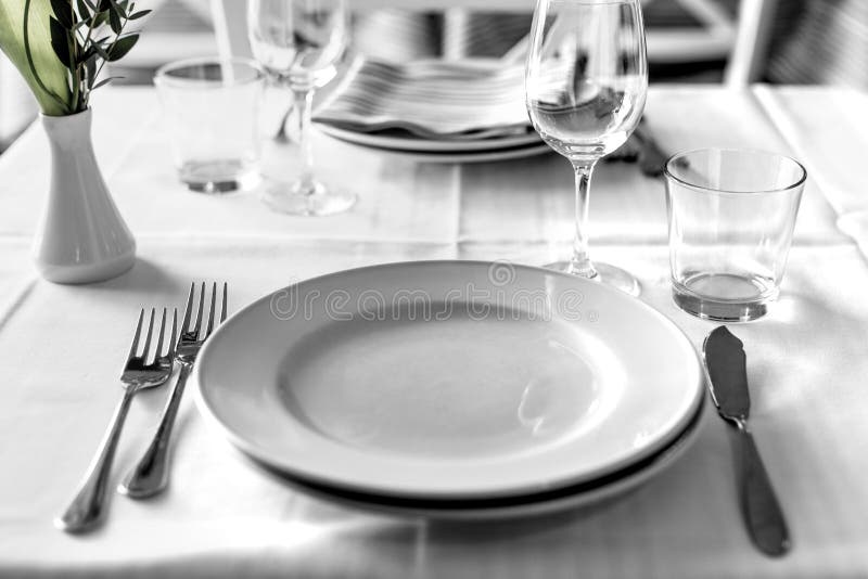 Table setting in restaurant interior, desaturated. Lunch table set in restaurant interior, cutlery royalty free stock image