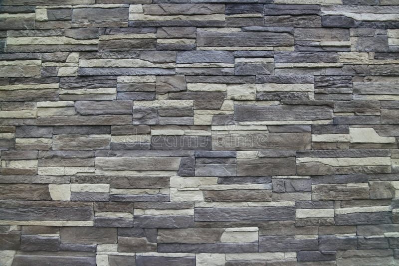 Texture - artificial decorative stone façade. Decorative grey color rough stone wall background texture. stock images