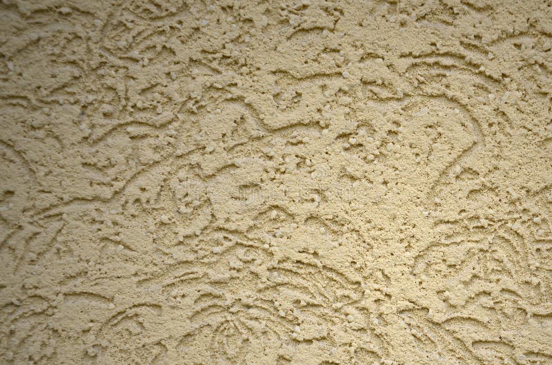 The texture of the beige decorative plaster in bark beetle style. Russian variation of decorating facade walls royalty free stock photo