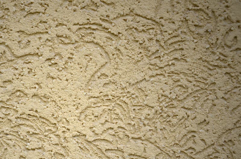 The texture of the beige decorative plaster in bark beetle style. Russian variation of decorating facade walls stock photo