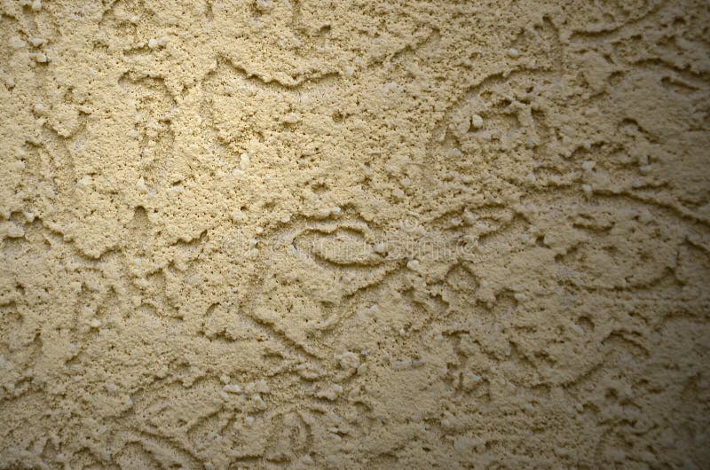 The texture of the beige decorative plaster in bark beetle style. Russian variation of decorating facade walls stock photos