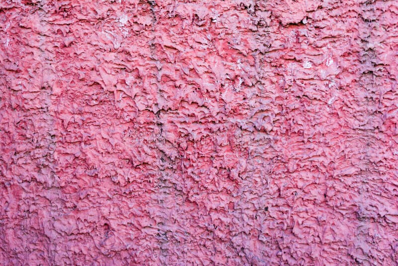 Texture of decorative plaster. External wall of the building. Pink rough background with purple spots. Horizontal royalty free stock photo