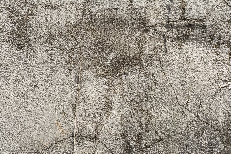 Texture of an embossed antique concrete wall with cracks and a ruined plaster protective layer. Abstract background stock photos