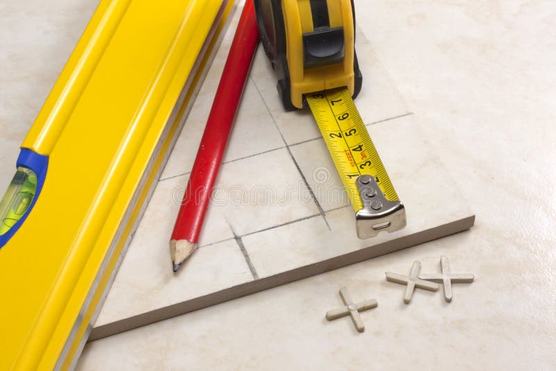 Tiler preparation for cutting tiles. Tiler is measured accurately tile before cutting in his own work place royalty free stock image