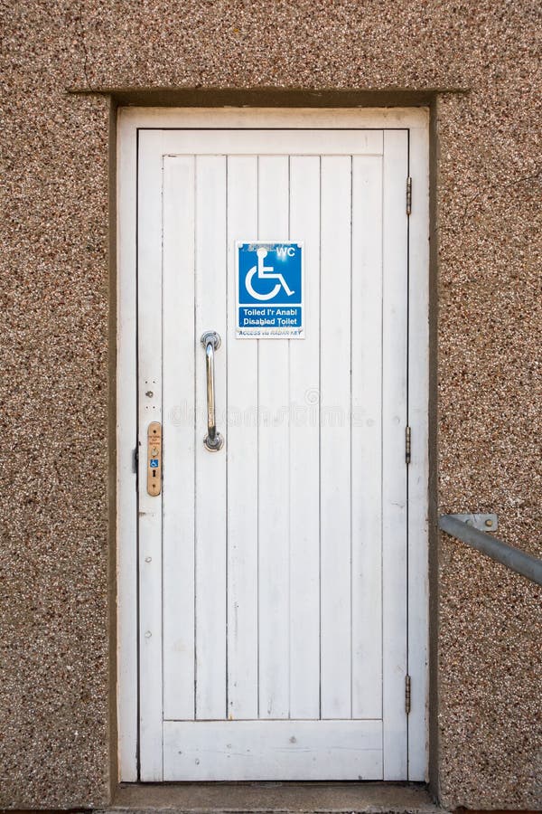 Toilet Door with Disabled Sign. White wooden door of a public toilet with a disabled sign stock images