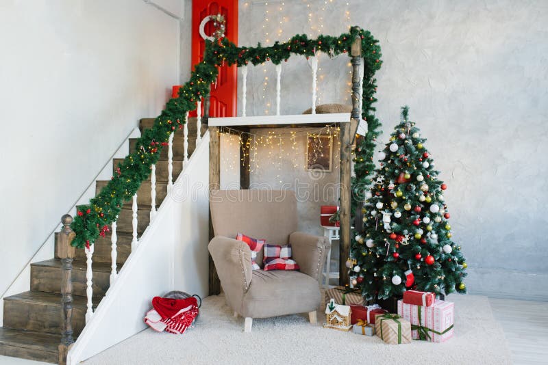 Traditional classic Christmas tree and beige armchair, stairs to the second floor in the living room or dining room. In the house royalty free stock photos