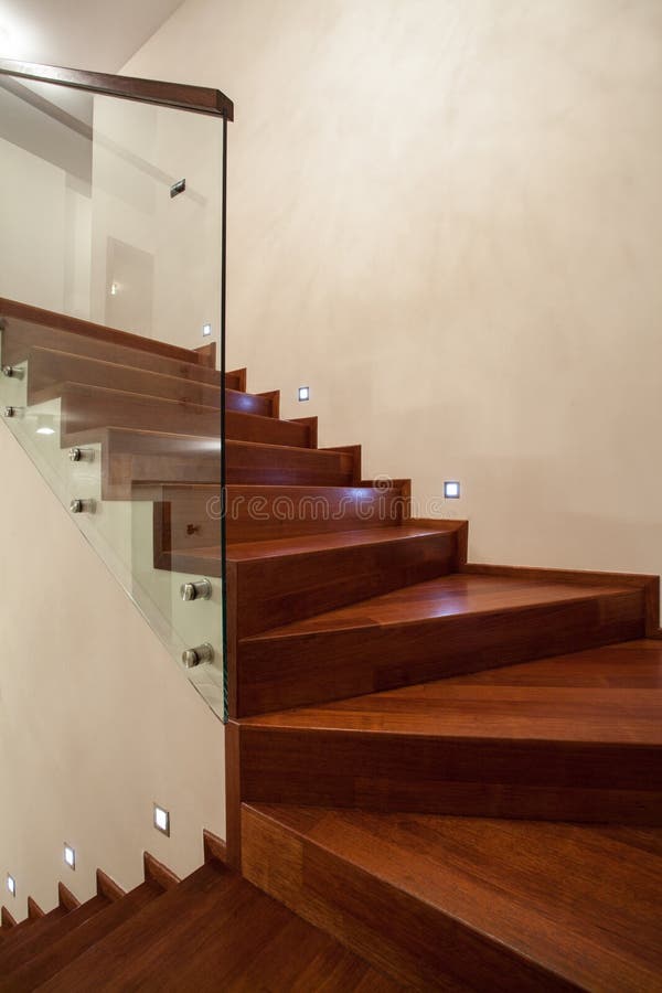 Travertine house- Closeup of wooden, glass stairs. In modern interior royalty free stock photos