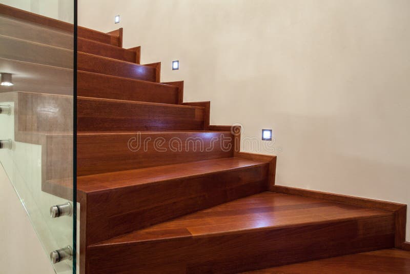 Travertine house- Stairs in close up. Travertine house- Horizontal view of brown, wooden stairs in luxury interior royalty free stock image