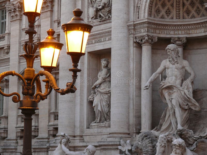 Trevi Fountain at dusk. Travertine marble statues and lit street lamps. Rome, Lazio, Italy. About 05/2011. Trevi Fountain at dusk. Travertine marble statues and royalty free stock photo