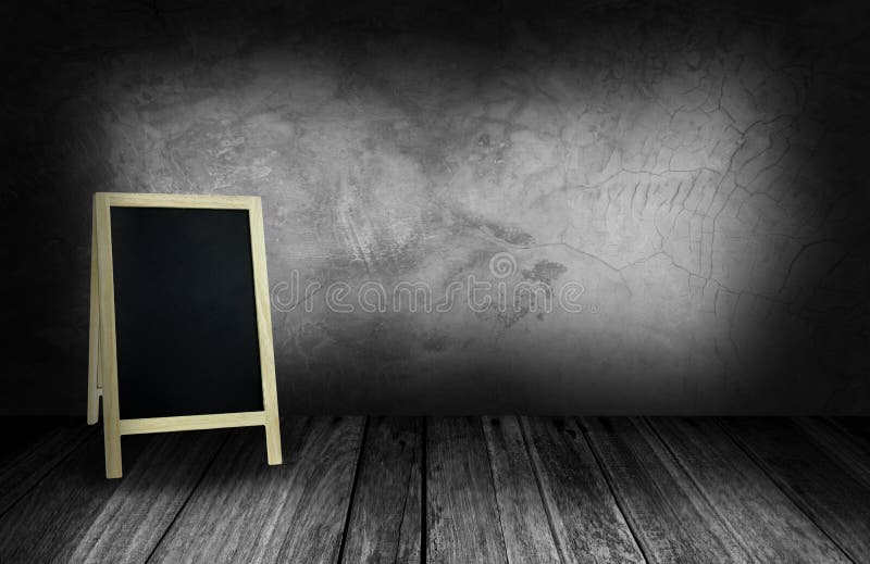 Tripod blackboard in interior room with gray stone wall.  stock images