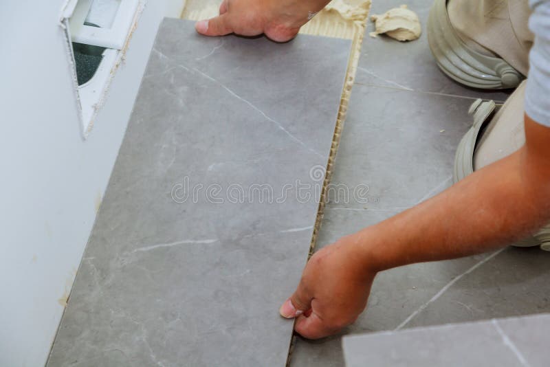 Troweling mortar a concrete floor in preparation for laying floor tile. Troweling mortar a concrete floor in preparation for laying floor ceramic tiles tiled stock photography