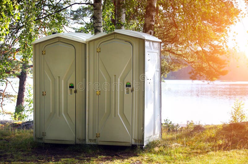 Two portable toilet. Or loo in plastic at a park stock image