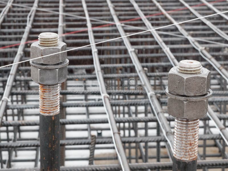 Two steel anchor bolts with nuts. And steel grid on tower crane footing reinforcement royalty free stock photos