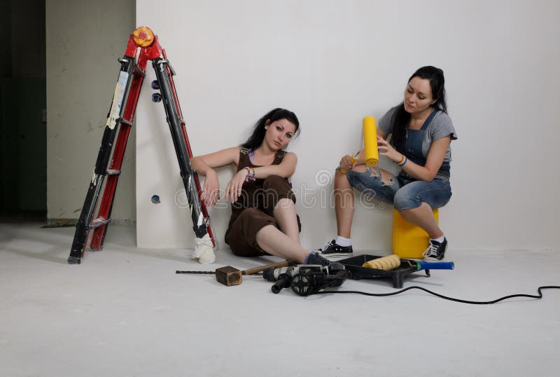 Two young women renovating a house stock photo